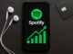 Interface Spotify sur smartphone avec graphique en hausse, symbolisant l’achat de streams et les stratégies de promotion musicale.